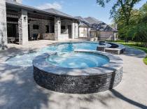 Freeform pool with raised spa, raised wall and bubblers
