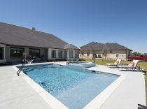Geometric Pool and Spa with Sheer Descent Tanning Deck and Basketball Goal 80K-to-100K
