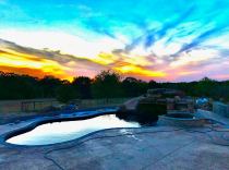 Freeform pool with raised spa, rock waterfall & slide combo