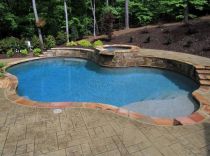 Freeform pool with raised wall and spa
