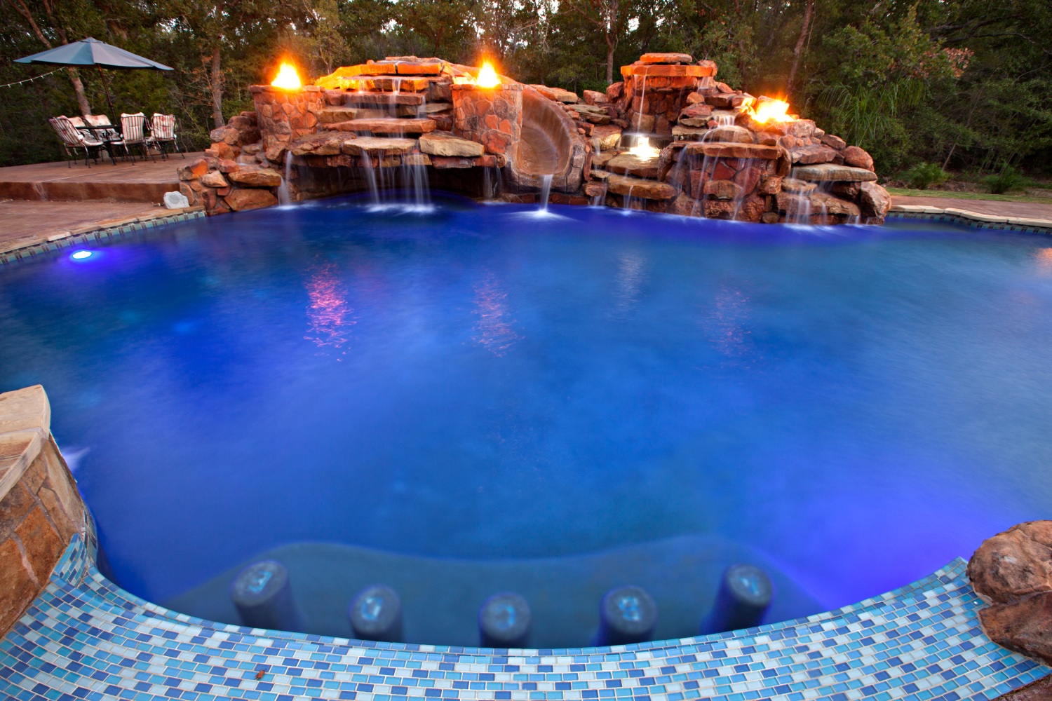 Custom gunite pool with fire bowls, slide and waterfall in College Station TX